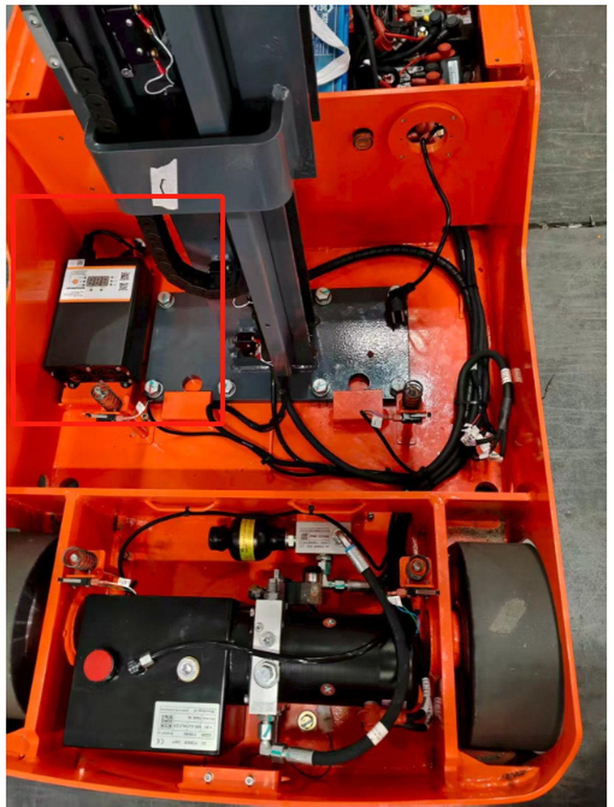 ALT-700 charger installed inside the sealed body cavity of a new-generation mast lift, alongside the hydraulic pack and electrical components.