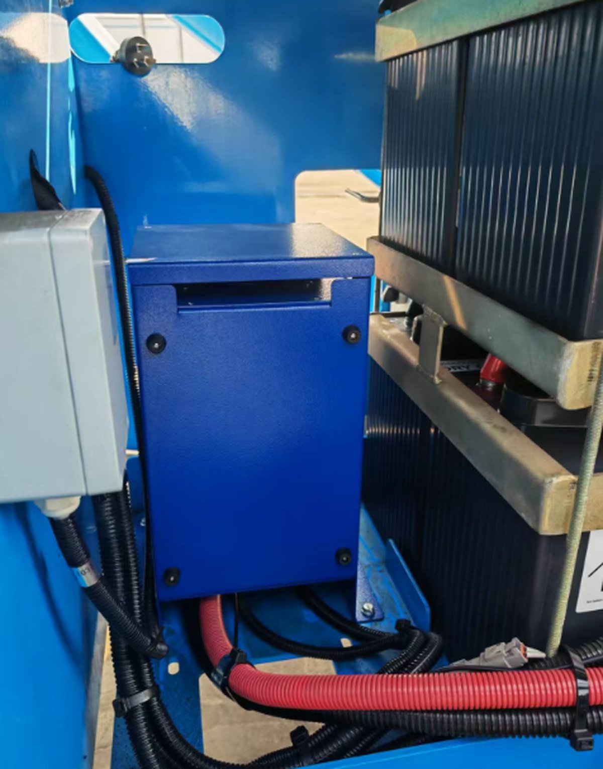 ALT-1700 charger fitted inside the on-board electrical compartment of a Chinese spider lift, between the battery pack and the chassis frame.